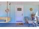 Inviting front porch with hanging swing, wicker seating, and bright blue wall at 1240 Georgia Ave, Dunedin, FL 34698