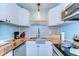 Modern kitchen with stainless steel appliances, white cabinets, herringbone countertops, and bright lighting at 1240 Georgia Ave, Dunedin, FL 34698