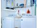 Efficient laundry room with washer, dryer, and overhead storage for organized convenience at 1240 Georgia Ave, Dunedin, FL 34698