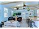 Open-concept living room featuring vaulted ceilings, wood beams, comfortable seating, and a ceiling fan at 1240 Georgia Ave, Dunedin, FL 34698