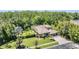 Elevated view of the home, lush lawn, and meticulous landscaping surrounded by verdant trees at 12801 Castlemaine Dr, Tampa, FL 33626