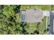 Aerial view of home showcasing pool and roof amidst lush green landscape at 12801 Castlemaine Dr, Tampa, FL 33626