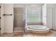 Bathroom offering soaking tub, glass shower enclosure and a glass block window at 12801 Castlemaine Dr, Tampa, FL 33626