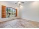 Bedroom featuring floor tiles, ceiling fan, shutters and a window showing tropical views at 12801 Castlemaine Dr, Tampa, FL 33626