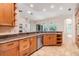 Open kitchen featuring wood cabinets, granite counters, stainless appliances and travertine flooring at 12801 Castlemaine Dr, Tampa, FL 33626