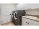 Laundry room showcasing a sink, countertop, cabinets, and gray washer and dryer at 12801 Castlemaine Dr, Tampa, FL 33626