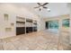 Open-concept living room featuring tile floors, recessed lights, a ceiling fan, and sliding doors to the pool area at 12801 Castlemaine Dr, Tampa, FL 33626