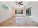 Living room with tile floors, ceiling fan, window and sliding door leading to the lanai at 12801 Castlemaine Dr, Tampa, FL 33626