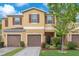 Inviting townhome featuring a well-maintained lawn, a two-car garage, and charming curb appeal at 12913 Dream Catcher Way, Riverview, FL 33579