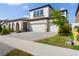 Inviting home exterior with a paved driveway leading to a three-car garage, complemented by manicured lawn at 13246 Twin Bridges Dr, Riverview, FL 33579