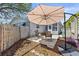 Cozy backyard patio area with pavers, lounge chairs, and shaded seating under an umbrella at 1344 Dartmouth Dr, Holiday, FL 34691