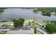 Aerial view of lakefront condos with a community pool, lush landscaping, and ample parking at 13833 Orange Sunset Dr # 201, Tampa, FL 33618