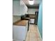 Efficient kitchen with white cabinetry, stainless steel appliances, and a tiled backsplash at 13833 Orange Sunset Dr # 201, Tampa, FL 33618