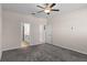 A cozy bedroom with carpet flooring, ceiling fan, and doorways leading to other rooms at 13871 Carlow Park Dr, Riverview, FL 33579