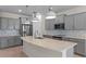 Well-lit kitchen featuring gray cabinets, stainless steel appliances, a large island, and tiled backsplash at 13871 Carlow Park Dr, Riverview, FL 33579