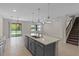 Bright kitchen island with sink, stylish gray cabinets, and open-concept layout to the living space at 13871 Carlow Park Dr, Riverview, FL 33579