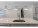Close-up on the kitchen island with double sinks and a view of the living room and staircase at 13871 Carlow Park Dr, Riverview, FL 33579