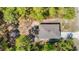 Aerial view of a wooded property featuring a home with a grey roof and a long driveway at 14020 Sooty Tern Ave, Brooksville, FL 34614