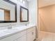 Bathroom featuring double sinks, white cabinets, framed mirrors, and a well-lit vanity at 14020 Sooty Tern Ave, Brooksville, FL 34614