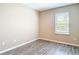 Bedroom with wood-look floors featuring neutral paint, and a window with blinds at 14020 Sooty Tern Ave, Brooksville, FL 34614