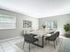 Sunlit dining room with sleek table set, complemented by views of the green outdoors from its window at 14020 Sooty Tern Ave, Brooksville, FL 34614