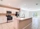 Well-lit kitchen featuring stainless steel appliances, ample counter space, and a breakfast bar on the center island at 14020 Sooty Tern Ave, Brooksville, FL 34614