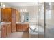 Bathroom with double sinks, cabinets, bathtub, and a tiled shower at 14418 Mirabelle Vista Cir, Tampa, FL 33626