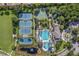 Aerial view highlighting tennis courts, a basketball court, and a pool area surrounded by trees and landscaping at 14418 Mirabelle Vista Cir, Tampa, FL 33626