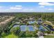 Aerial view capturing tennis courts, landscaping, a pool area, and community amenities nestled amidst a wooded area at 14418 Mirabelle Vista Cir, Tampa, FL 33626