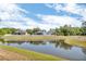 Scenic backyard view of pond reflecting the sky and surrounded by a fence line of surrounding houses at 1536 Norwick Dr, Lutz, FL 33559