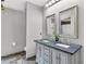 Bathroom featuring double vanity with gray cabinets, granite countertop and matching framed mirrors at 1536 Norwick Dr, Lutz, FL 33559