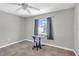 Bedroom features neutral paint, single window with curtains, tile floor, and rolling desk chair at 1536 Norwick Dr, Lutz, FL 33559