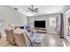 Comfortable living room with tile floors, ceiling fan, large TV, and access to outdoor patio at 1536 Norwick Dr, Lutz, FL 33559