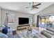 Comfortable living room with tile floors, ceiling fan, large TV, and access to outdoor patio at 1536 Norwick Dr, Lutz, FL 33559