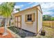 Backyard shed with double doors and window with shutters surrounded by a wood fence line at 1536 Norwick Dr, Lutz, FL 33559