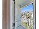 View from the balcony overlooking lush landscaping, palm trees, and neighboring buildings at 17960 Gulf Blvd # 111, Redington Shores, FL 33708