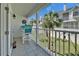 Relaxing balcony featuring tiled floors, outdoor seating, and a view of the community's lush landscaping at 17960 Gulf Blvd # 111, Redington Shores, FL 33708