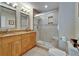 Well-lit bathroom features double sinks with granite countertops and a large walk-in shower with tile accents at 17960 Gulf Blvd # 111, Redington Shores, FL 33708