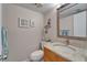 Updated half bathroom with a granite countertop, decorative mirror, and lovely decor at 17960 Gulf Blvd # 111, Redington Shores, FL 33708