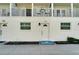 Charming white exterior featuring a welcome mat, updated windows, and a cozy balcony overlooking the front yard at 17960 Gulf Blvd # 111, Redington Shores, FL 33708