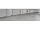 View of the garage and parking area featuring assigned spaces with garages and neutral color concrete flooring at 17960 Gulf Blvd # 111, Redington Shores, FL 33708