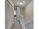 Bright upstairs hallway with wood-look floors, white railings, and access to bedrooms with closet space at 17960 Gulf Blvd # 111, Redington Shores, FL 33708
