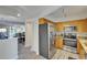 Modern kitchen with stainless steel appliances and warm wood cabinetry, seamlessly flowing into the living area at 17960 Gulf Blvd # 111, Redington Shores, FL 33708