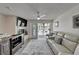 Living room with fireplace, TV, leather sofa, and sliding glass doors to a balcony at 17960 Gulf Blvd # 111, Redington Shores, FL 33708