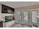 Living room with fireplace, TV, and sliding glass doors leading to a balcony at 17960 Gulf Blvd # 111, Redington Shores, FL 33708