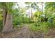 The property features a beautifully landscaped yard with a garden path, lush greenery and mature trees at 1880 Belleair Rd, Clearwater, FL 33764