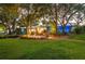 A beautiful landscaped backyard with lush green grass, garden beds, and a cozy seating area around the house at 1880 Belleair Rd, Clearwater, FL 33764
