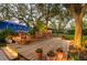 Serene backyard with a wooden deck, rocking chairs, mature trees and landscape lighting at 1880 Belleair Rd, Clearwater, FL 33764