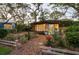 Charming backyard studio with inviting light, surrounded by lush greenery and colorful roses in a serene setting at 1880 Belleair Rd, Clearwater, FL 33764