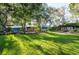 Expansive backyard featuring a lush lawn, mature trees, and a charming home with inviting outdoor seating at 1880 Belleair Rd, Clearwater, FL 33764